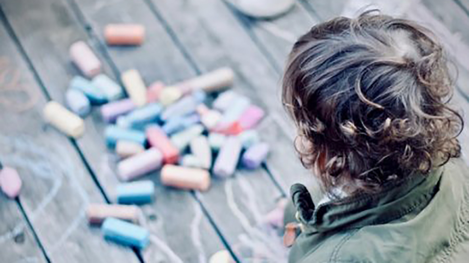 Child drawing with chalk